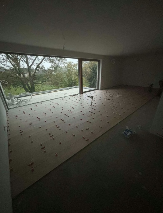 Pose de carrelage grand format devant une baie vitrée