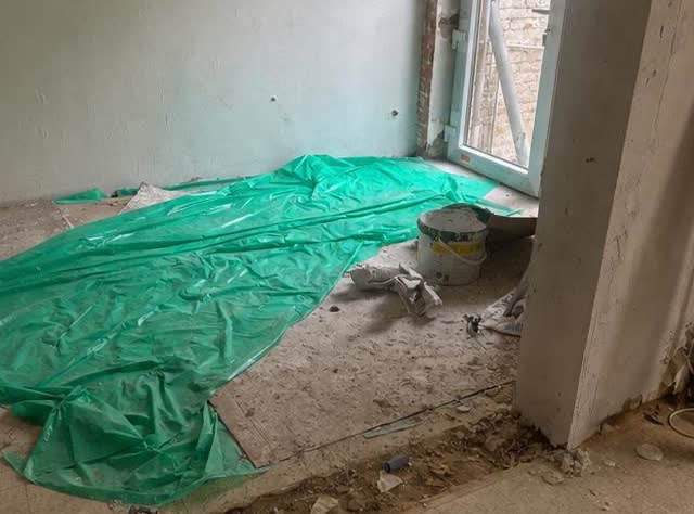 La pièce avant intervention : chape brute, bâche de protection et gravats