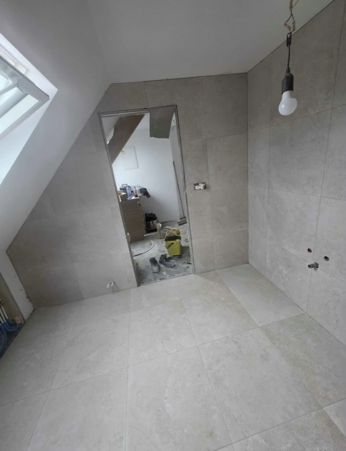 Salle de bain sous combles terminée, carrelage gris et douche
